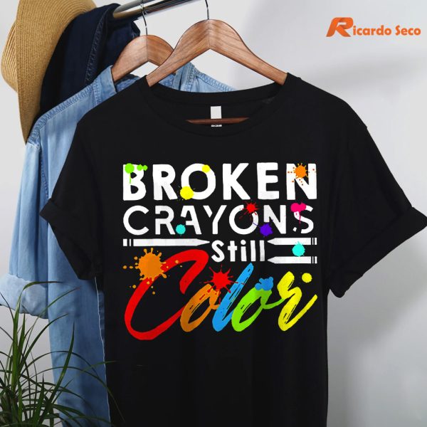 Broken Crayons Still Color T-shirt hanging on a hanger