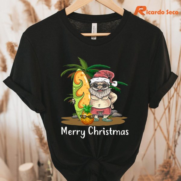 Christmas Palm Tree Tropical Xmas Coconut Santa Surfing T-Shirt hanging on a hanger