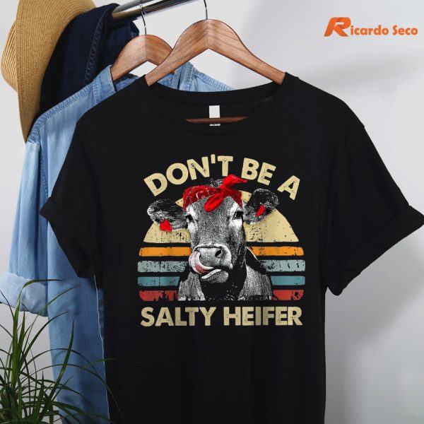 Don't Be A Salty Heifer T-shirt hung on a hanger