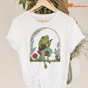 Frog Playing Banjo on Mushroom T-shirt hanging on a hanger