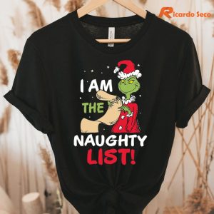 I Am the Naughty List Christmas Grinch T-shirt hung on a hanger