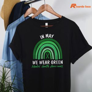 In May We Wear Green Mental Health Awareness T-shirt hanging on a hanger
