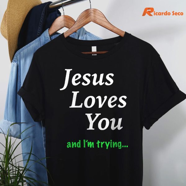 Jesus Loves You & I'm Trying T-shirt hanging on a hanger