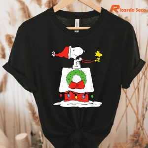 Peanuts Holiday Snoopy's Doghouse Sleigh T-Shirt hanging on a hanger