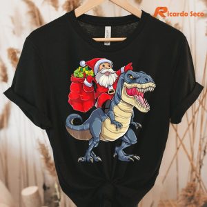 Santa Riding Dinosaur Christmas T-shirt hung on a hanger