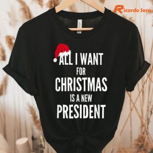 All I Want For Christmas Is A New President Santa Hat Tshirt hung on a hanger