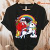 Christmas Santa Riding Unicorn Xmas Rainbow T-shirt hung on a hanger